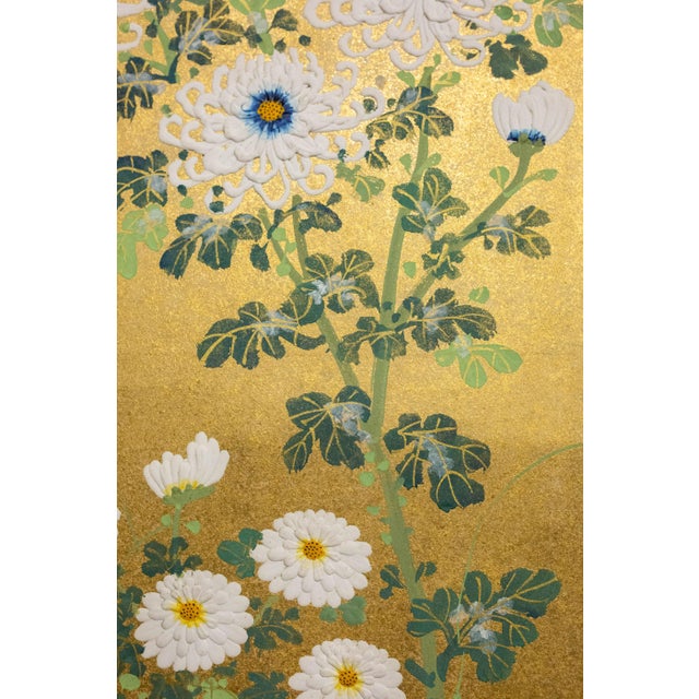 This elegant late 19th-century Japanese two-panel screen features a graceful arrangement of blooming chrysanthemums rising...