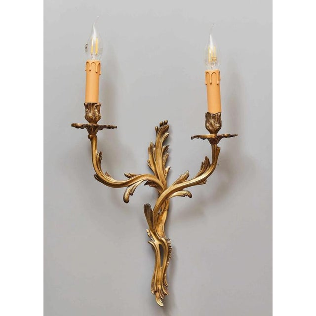 Wall lamps made of cast brass in the louis xv style. Heavy. Detailed workmanship. The lamps each hold two bulbs with an...