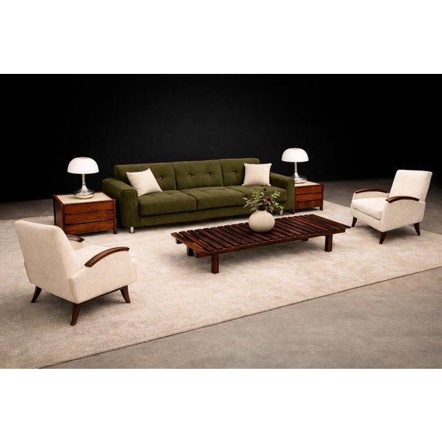 A striking study in sculptural woodworking and restrained Brazilian modernism, this exceptional pair of lounge armchairs...