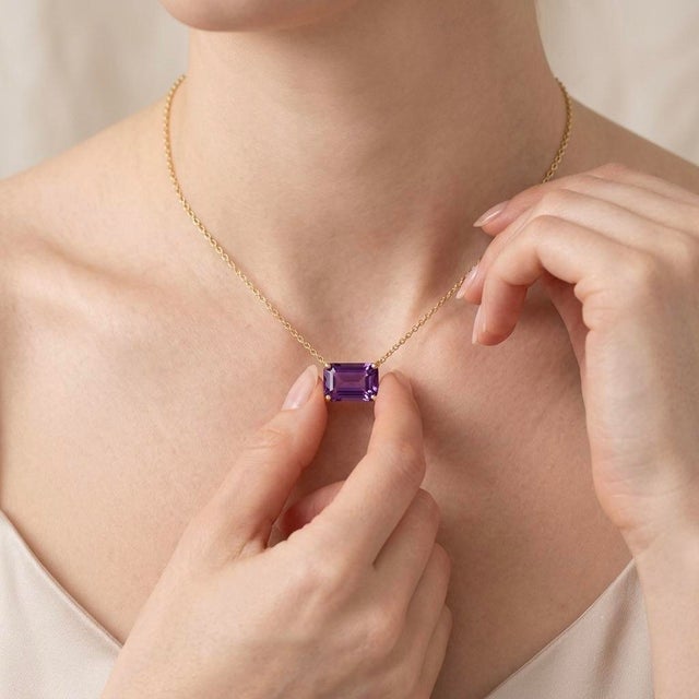 Exude effortless sophistication with this stunning East-West Emerald Cut Amethyst Necklace. This piece offers a...