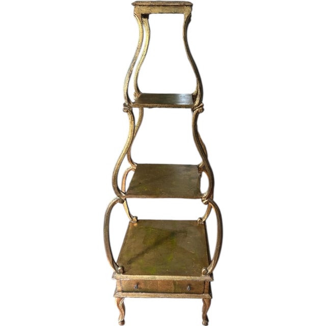 Gold Wood Florentine Etagere in a graduated pyramid shape of four shelves and one bottom drawer. Wonderful for displaying...