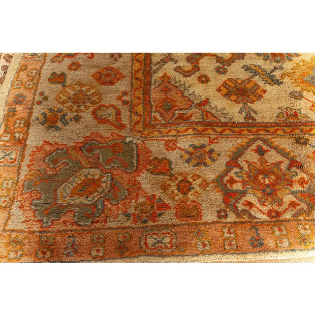 A splendid example of early 20th-century craftsmanship, this oversized antique Oushak rug from Turkey showcases the...