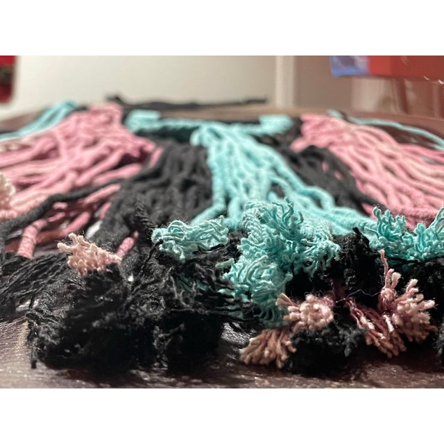 Decorative wall hanging featuring a crescent moon form constructed with macramé cotton cord and finished with long fringe...