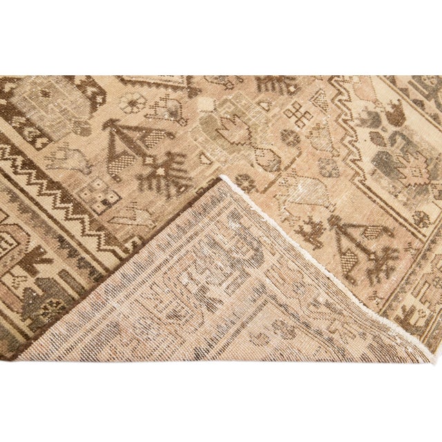 Beautiful vintage distressed medallion hand-knotted wool rug with a beige field. This rug has brown accents in a gorgeous...