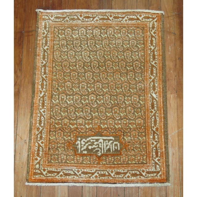 A signed Persian Tabriz mat in brown and orangem signed by weaver