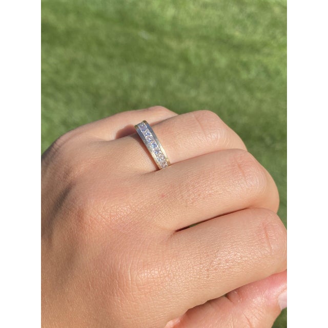 The 153rd Street: Channel Set Princess Cut Diamond Band in Yellow Gold. The band features a central channel set with a...