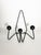 A vintage wall-mounted coat rack in black lacquered metal, featuring the minimalist, graphic design typical of the 1960s....
