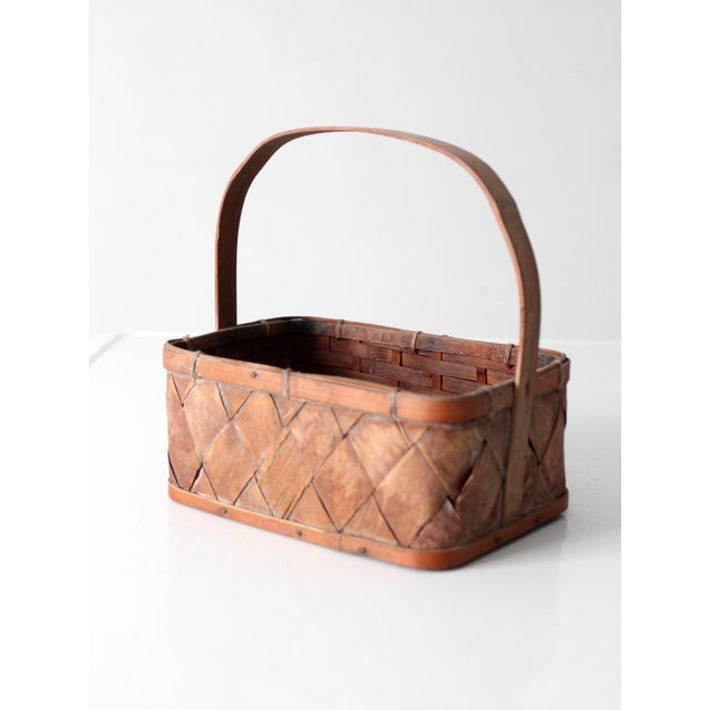 Vintage woven splint basket showcasing the beauty and simplicity of traditional handmade folk craft. The petite basket...