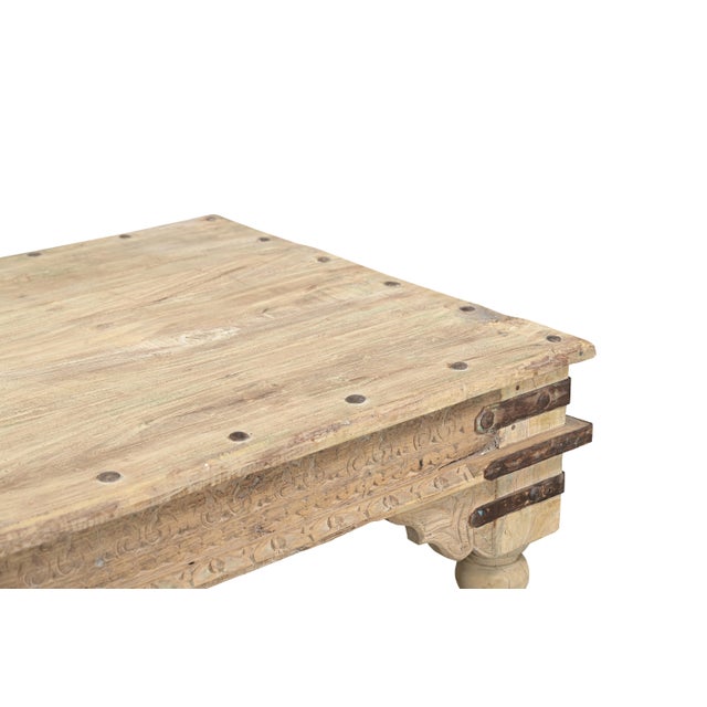 This Vintage Indian Bleached Teak Low Table is handcrafted from solid teakwood, featuring a substantial plank top, richly...