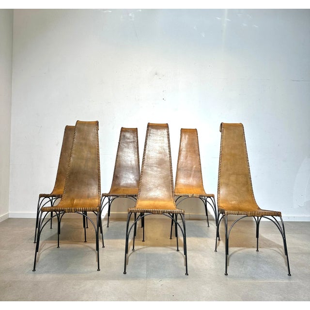 A striking set of six handcrafted dining chairs from Iran, showcasing an elegant combination of natural leather and cast...