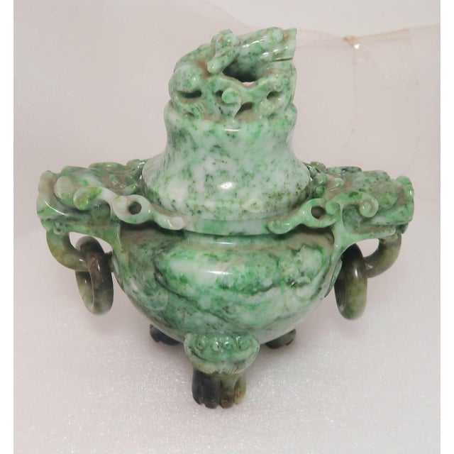This is a vintage Chinese Jade covered incense burner with tripod feet, Foo Dog finial and Dragon Head loose ring handles....