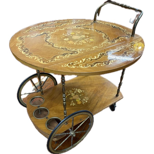 This elegant Italian drinks trolley features a folding drop-leaf top with intricate floral marquetry, scrolling inlay,...