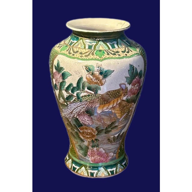Vintage Chinese chinoiserie vase in green and gold. Hand-painted birds nestled among blooming florals and lush foliage....