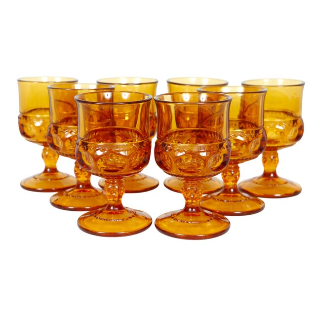 A set of eight amber glasses made by Colony for their Crown Topaz collection. Glasses are pressed with a crown thumb print...
