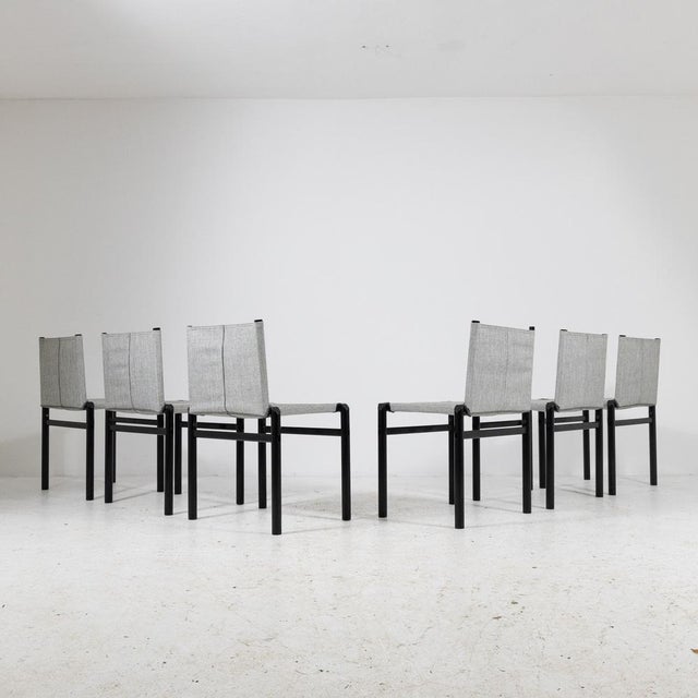 Iconic set of model chairs “Mastro”, featuring a basic black painted metal structure and a seat with a fabric backrest....