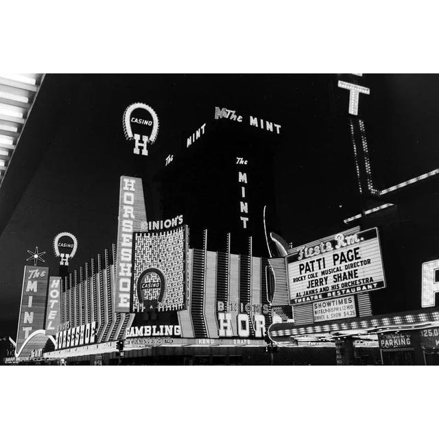 Black and white Print by Erich Andres, ca 1960. Bright neon signs light up Fremont Street in 1960s Las Vegas, showcasing...