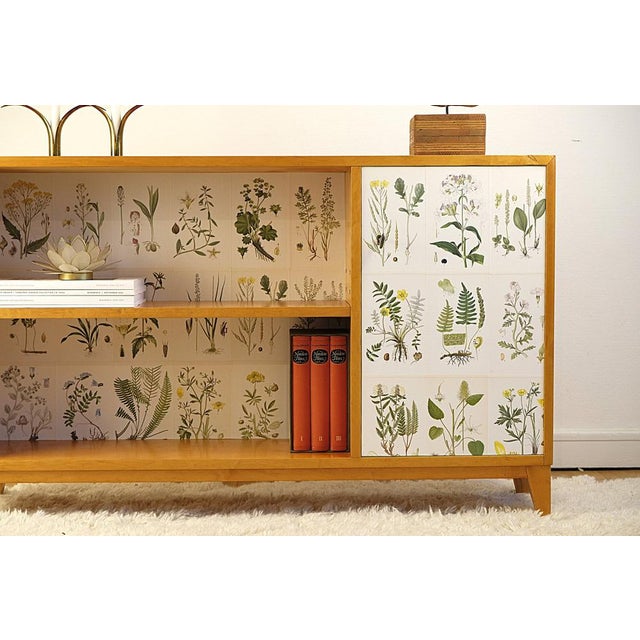 A charming piece of Swedish Modern / Swedish Grace bookcase from the 1940s, crafted in warm birch and lined with botanical...