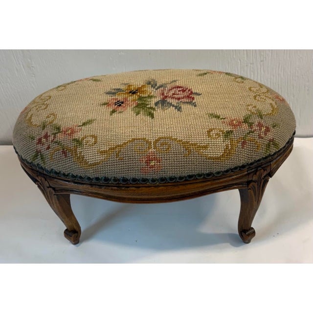 Beautiful antique French needlepoint footstool with carved cabriole legs and nail head trim.