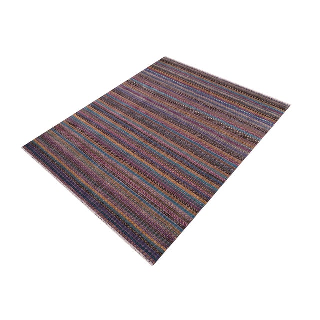 Elevate your interior with this hand-knotted high-low wool area rug, designed to bring depth and dimension to any room....