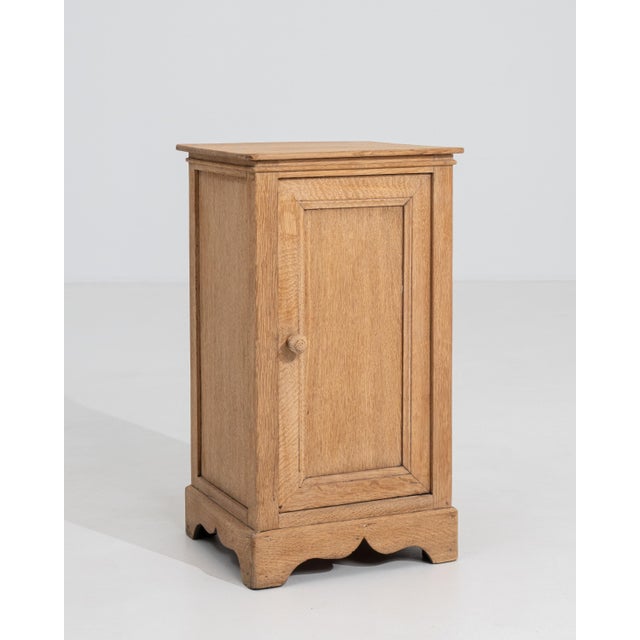 A 19th century French side table in the Louis Philippe style, featuring a compact cabinet form with a single door and...