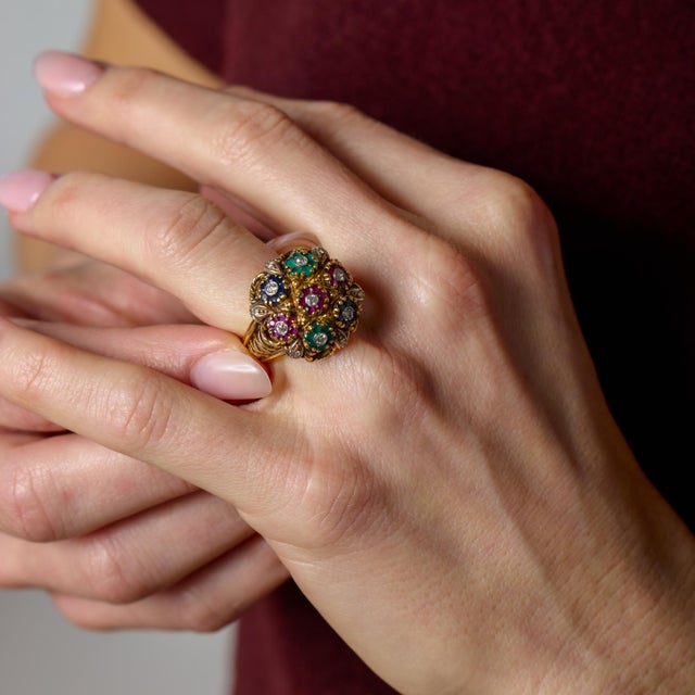 This vintage cocktail ring is a vibrant celebration of color and form, designed as a lush gemstone bouquet that captures...