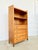 A 1940s-50s solid oak bookcase/chest of drawers, featuring two open shelves and four drawers with molded fronts and round...