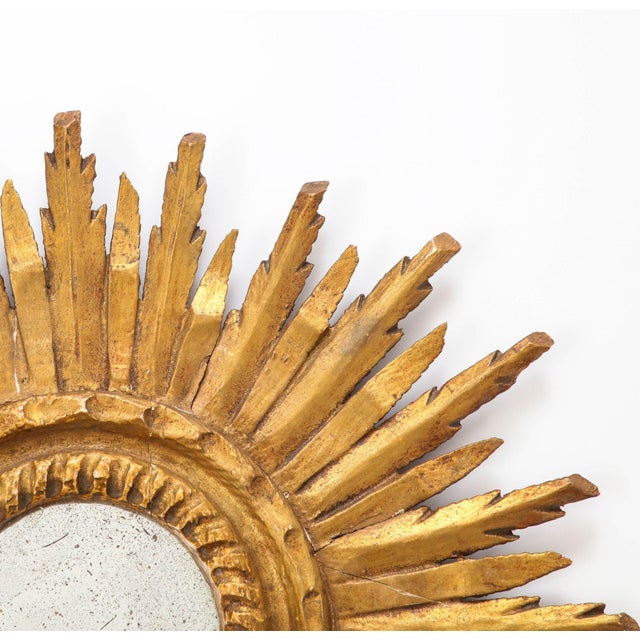 An early 20th century small French sunburst mirror. The classic sunburst frame is made of giltwood and has mirror plate...