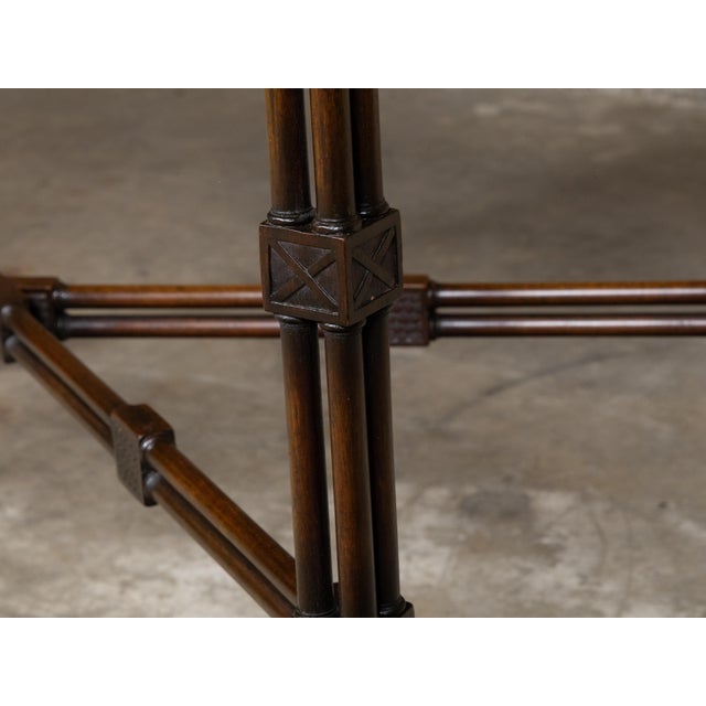 An English mahogany side table from the 19th century with carved tray top, faux bamboo base, cross stretcher, rosettes and...