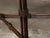 An English mahogany side table from the 19th century with carved tray top, faux bamboo base, cross stretcher, rosettes and...