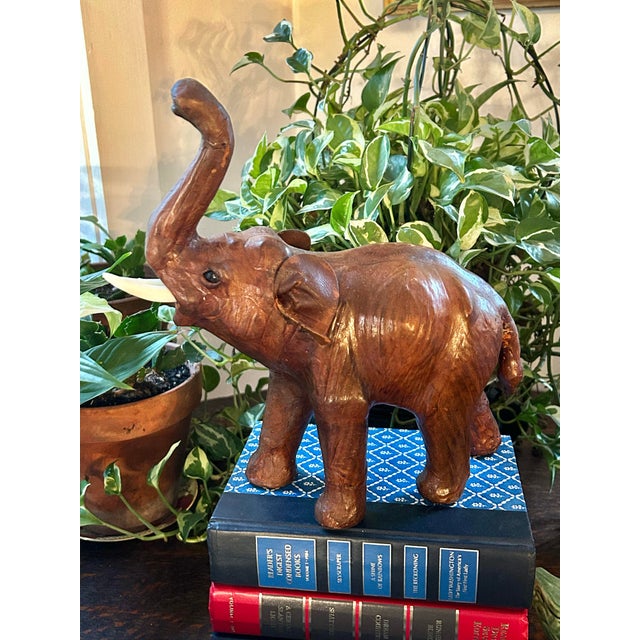 This leather wrapped elephant has its trunk up for good luck! Created from leather covering paper mache, the size allows...