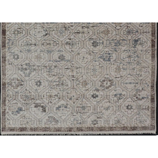This modern tribal Oushak rug has been hand-knotted in wool. The rug features a modern, all-over sub-geometric design,...