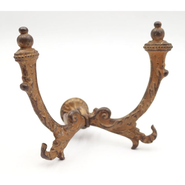 Antique Victorian hall tree hook made of cast iron with a tan painted distressed finish. There is a screw attached to the...