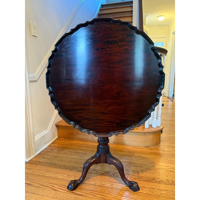This is a magnificent tilt-top Chippendale style tea table in mahogany, with pie crust top. The table top is supported on...