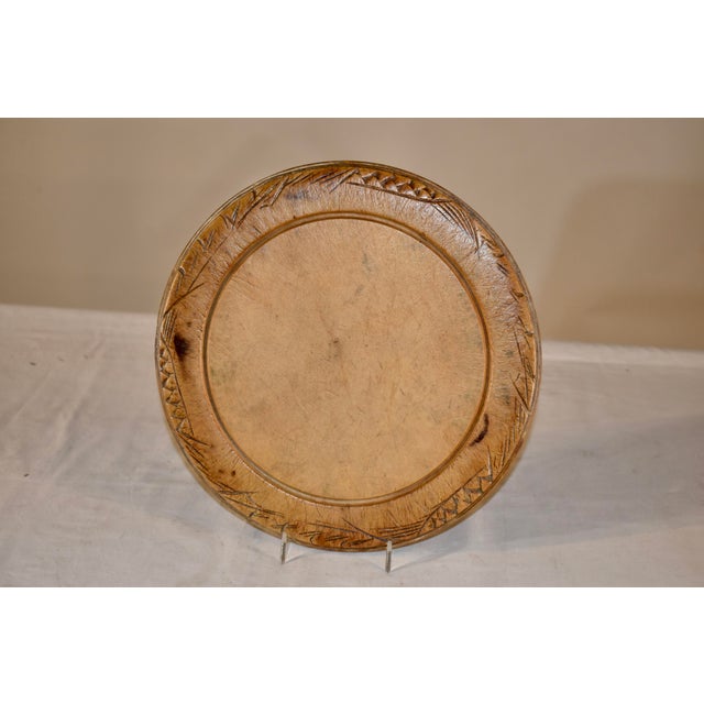 19th century sycamore bread board from England with hand carved wheat decoration around the edges, surrounding the central...