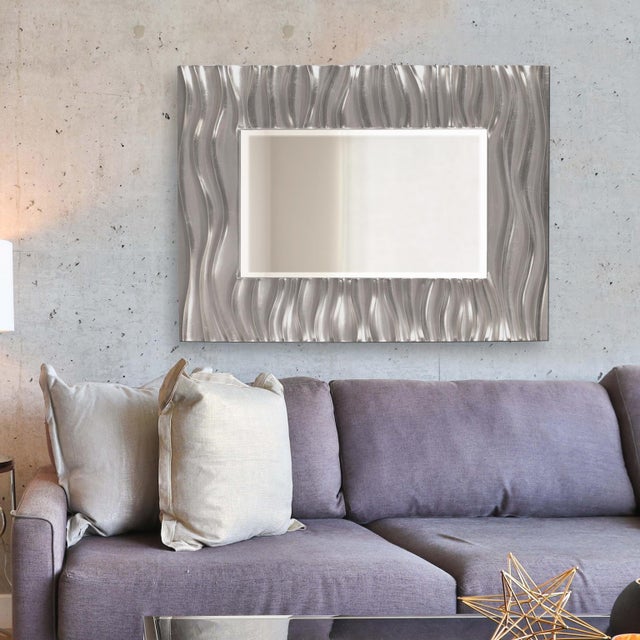 Our Zenith Mirror features a rectangular frame that is characterized by a deep textured wave design. The waves give an...