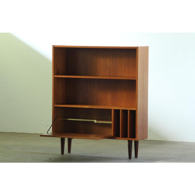 A matching pair of slim Danish teak bookcases from the 1960s, sold as a set. Their narrow proportions make them...