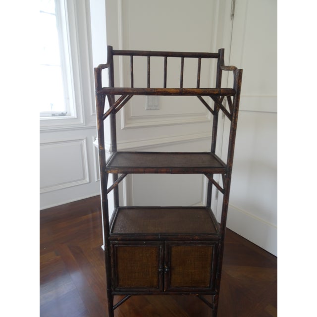 A vintage burnt Bamboo Etagere with 3 shelves and a two door storage compartment. Great for a bathroom, powder room, or...