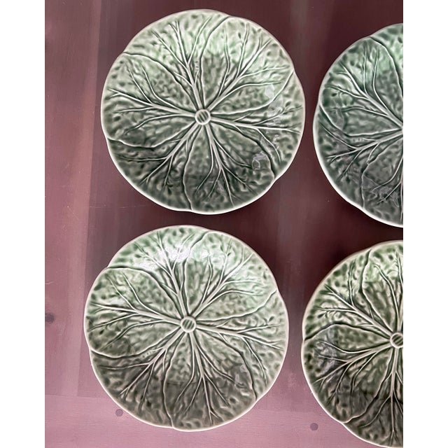 A striking set of four Portuguese majolica plates from the beloved Bordallo Pinheiro workshop, featuring the iconic...