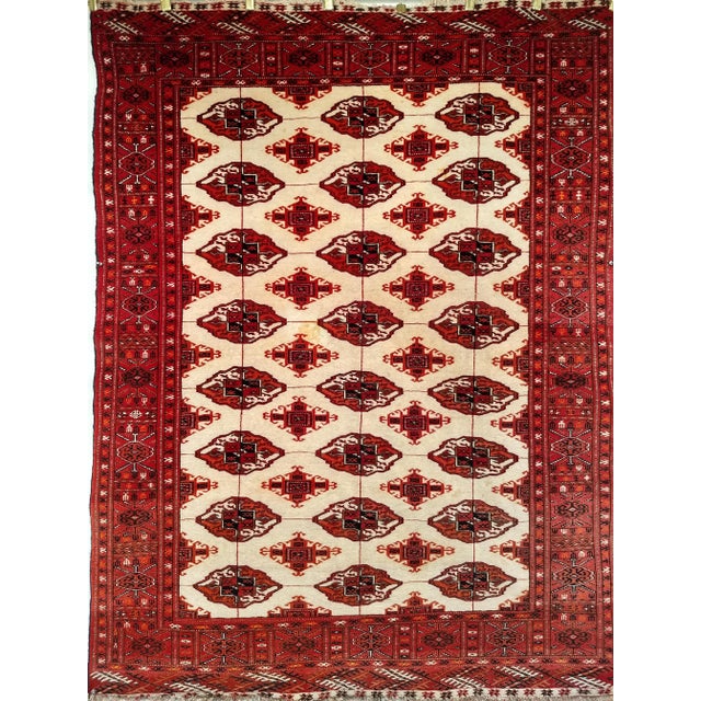 The Turkmen carpet with a traditional small star medallion design covering the field. The field color in this Turkmen rug...