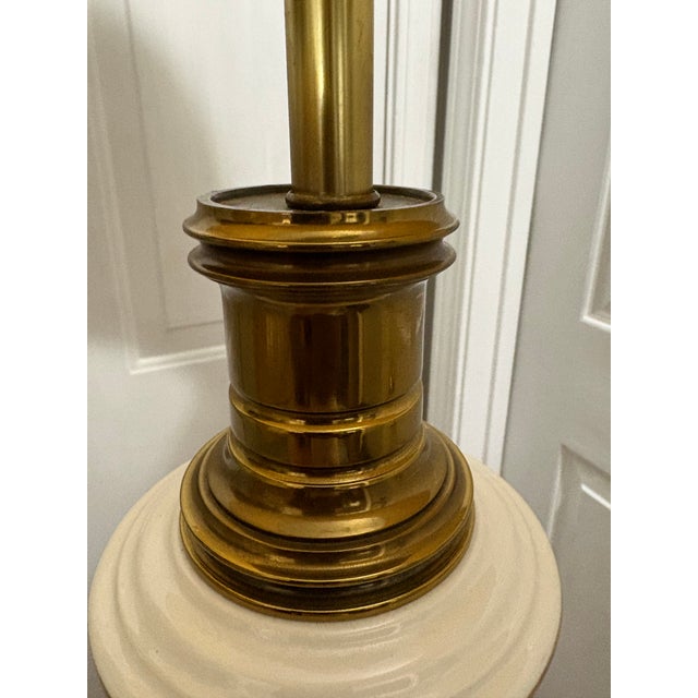 This is a vintage Hollywood Regency style cream and brass table lamp,heavy, high-quality solid brass construction and...