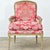 A French Louis XV – Louis XVI transitional bergere with carved details and a painted finish. The chair has a curved back...
