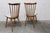 Discover this pair of Baumann Menuet chairs, a true ode to vintage design. with their honey-patina finish and white vinyl...