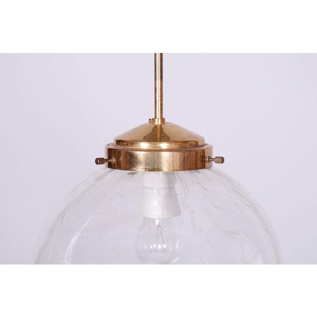 This chandelier is a refined example of 1960s Czechoslovak design, produced in the prestigious glassworks of Kamenický...