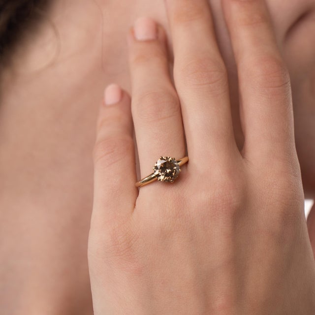 This elegant vintage diamond engagement ring is a striking design from the 2000’s, centered by a GIA-certified round...