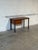 This rectangular desk features a sleek profile defined by functional simplicity. The minimalist design highlights a single...