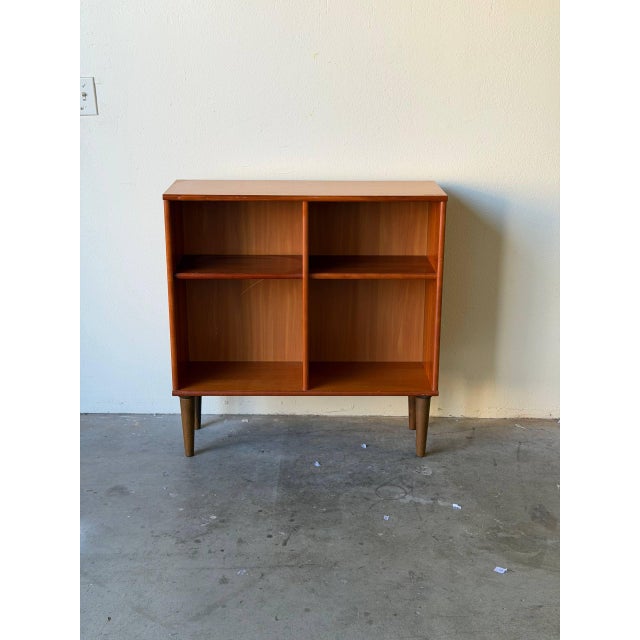 Beautiful Mid Century Modern Danish bookcase crafted in warm teak wood, featuring clean Scandinavian lines and a light,...