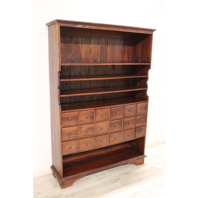 We present this unique vintage bookcase from the 1990s in solid walnut. Its design is rustic and simple, devoid of...