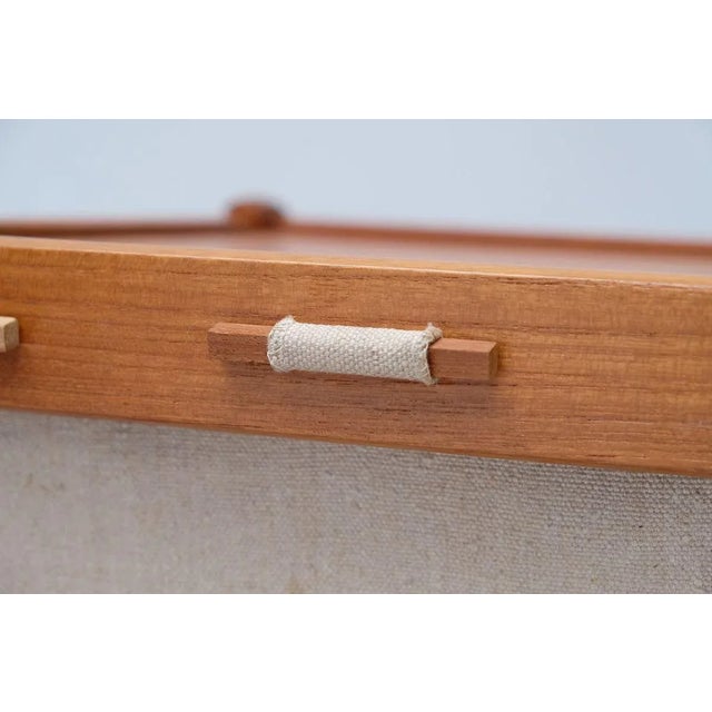 Small side table from the 60s of the Danish manufacturer Spøttrup. It is made of teak and has a magazine tray from linen....