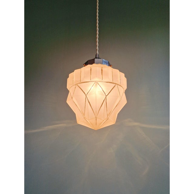 Art Deco frosted glass pendant light with a chrome metal bracket, 1920s-30s. The pendant light has been restored and...
