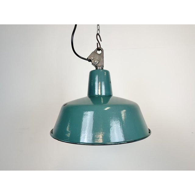 Industrial green enamel pendant light made by Polam Wilkasy in Poland during the 1960s. White enamel inside the shade....